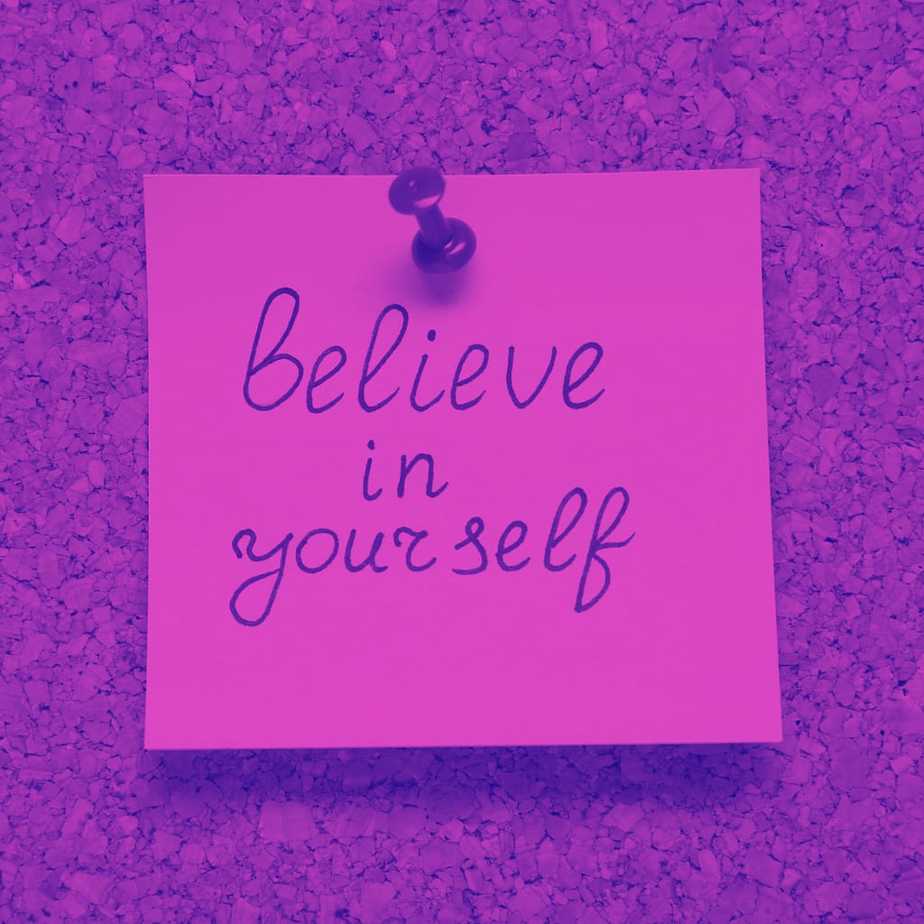 Image that shows a post it tacked to a corkboard with the words believe in yourself.