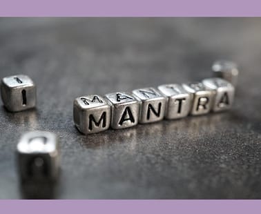 Image of the word Mantra spelled out in silver dice with letters on them.