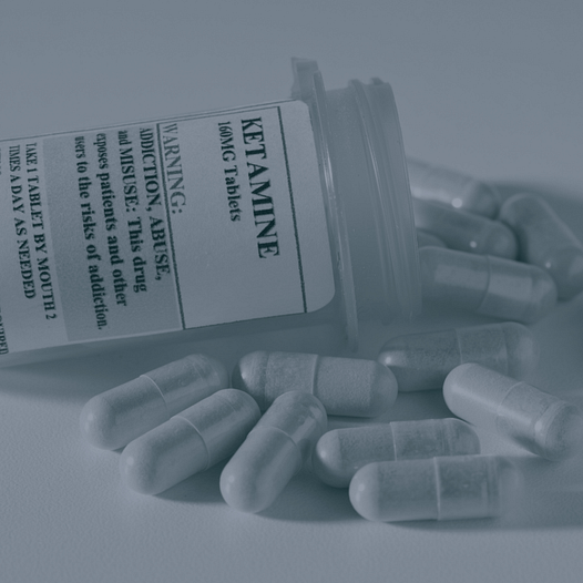 Ketamine prescription bottle on side with capsules spilling out