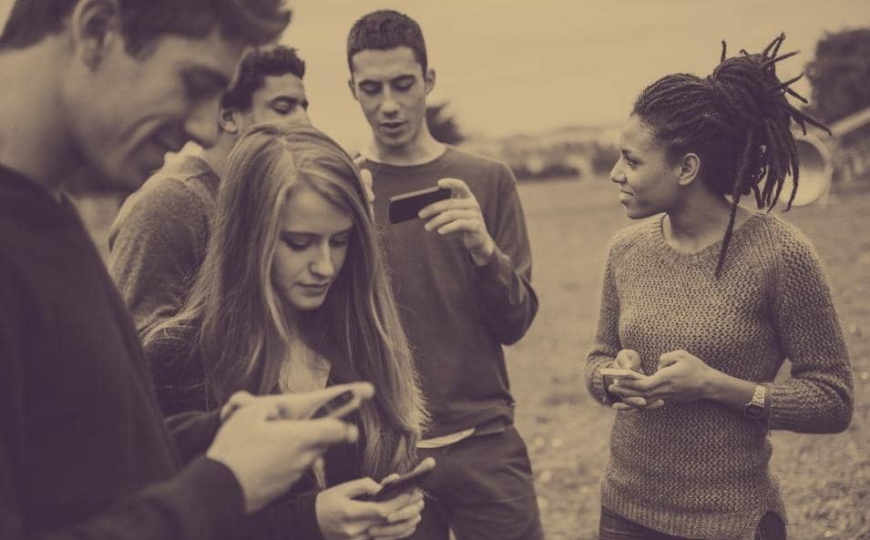 Photo of a bunch of kids all using their phones to communicate.