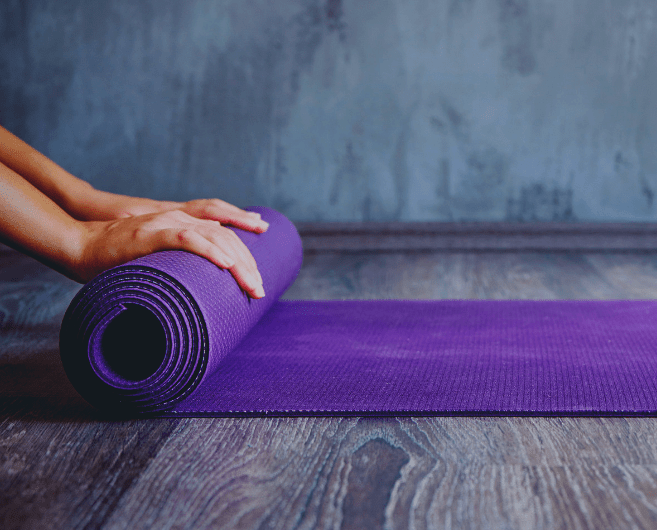 woman rolling up yoga mat to indicate conclusion